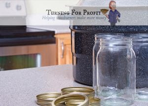 A canning pot, jars and lids sitting on a counter