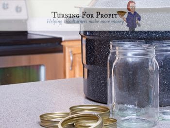 A canning pot, jars and lids sitting on a counter