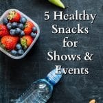 A water bottle, fruit and nuts on a black background